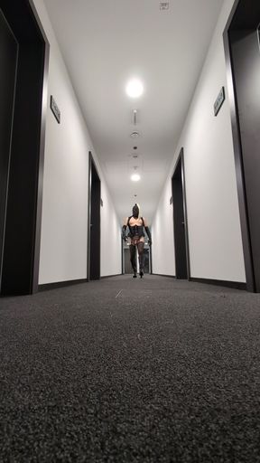 Masked Crossdresser Sissy walking in a hotel corridor.