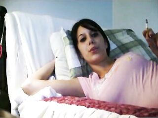 Woman with pink top smokes in couch