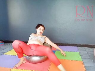 Regina Noir. A woman in yoga leotards practices yoga in the gym. Transparent red leotard yoga. two