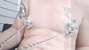 6 needles through the nipples stretched by plastic flower ring with holes on the terrace outside