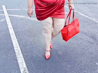 Gorgeous woman walking outdoors in public parking lot showing off for strangers