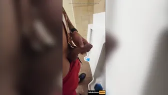 JohnHolmesJunior strokes big cock in busy public restroom