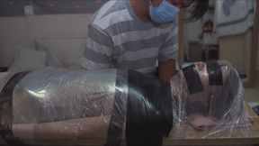 Mummy restrained with plastic wrap tape on a bench