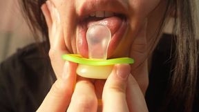 I find a pacifier and a piece of chewing gum under my pillow. I'm surprised by it. Then I start sucking the pacifier and chewing gum. I make bubbles while chewing the pacifier. Then I masturbate. I play with my pussy