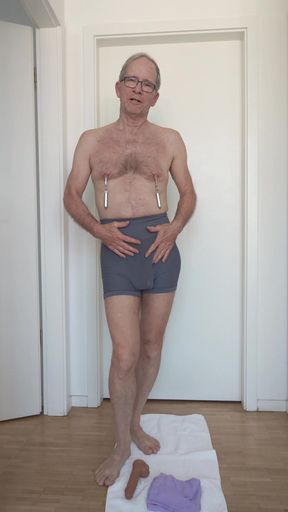 The grey shorts fit the slave&#039;s body well and show a nice bulge in the front.