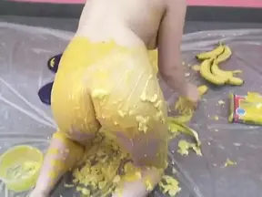 Ponytailed brunette covers her ass with smashed bananas