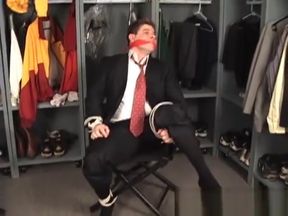 Suited coach tied to chair and cleave gagged in the locker room