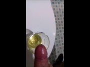 A guy in sweatpants pisses and cums in a glass for his friend, who then drinks it