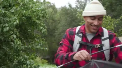 Inside The Tent, A Busy Camper Is Analized By A Friend