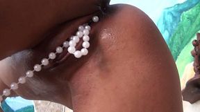 Ebony woman Kyra Black shoves beads necklace up her soaking pussy