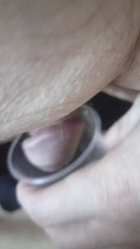 Jerking dick for cum in plastic cup.