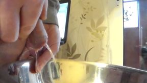 Closeup of John peeing into a steel bowl