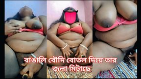 A Bengali woman quenches her thirst with a bottle