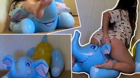 Naomi, barefoot and wearing mini-shorts, stomps on a large inflatable elephant; she steps on it with her full weight—its legs, head, and trunk—crushing it down, jumping on it, and sitting on it. Sexy bottom.