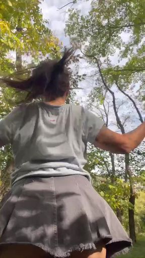 Woman in skirt jumping on trampoline