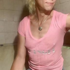 Soaking wet in bathroom in pink t-shirt, denim skirt and socks