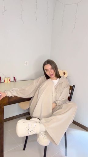 Woman in white jumpsuit sitting on chair