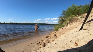 Fishermen swim past a beautiful nudist woman