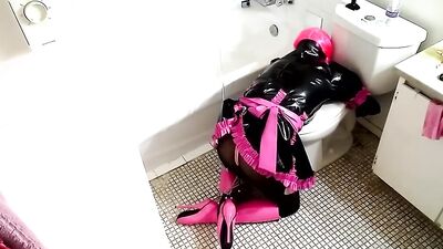 Slave in latex is waiting for his master handcuffed in the bathroom