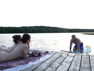 two gals took their clothing off on the lake. A passing surfer had sex in the open air.