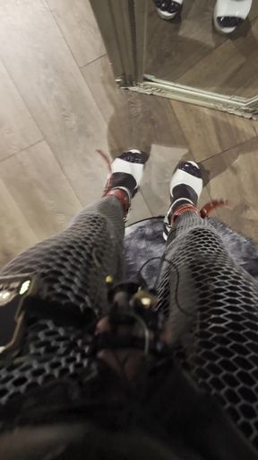 Sexy babe in a catsuit, latex gloves, high heels, and chastity