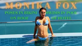 Busty Russian MILF poses and swims in a bikini on a rooftop pool
