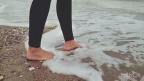 Seule sur le sable, les pieds dans l’eau