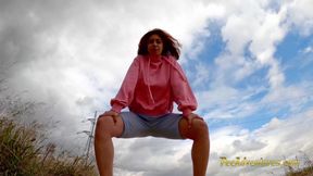 Running outdoors and pee with her legs wide opened outdoor