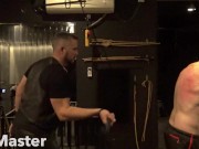 Slave on St Andrews Cross whipped with floggers turning his back from white to red. PREVIEW