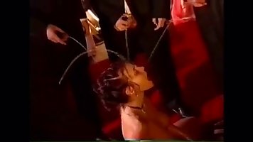 Naked slut is kneeling on the floor, while horny guys are pissing all over her body