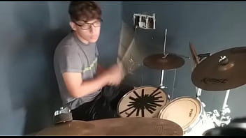 Menino tocando uma com sua baqueta