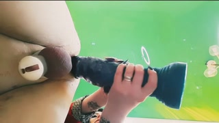 Bottom view, slave in chastity belt takes big toys into his hole