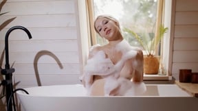 Petite blonde teen gets naked in the bathtub to reveal soapy tits