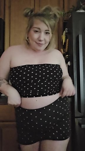 Curvy blonde woman in black and white polka dot crop top
