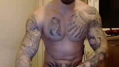 Tattooed Guy Flexes for Camera