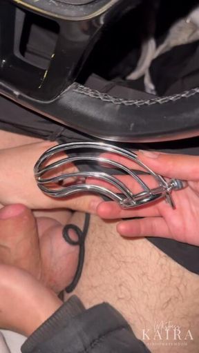 Mistress Kaira te pone la jaula de castidad en el coche mientras pasa gente.