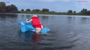 Riding a transparent inflatable whale on a lake