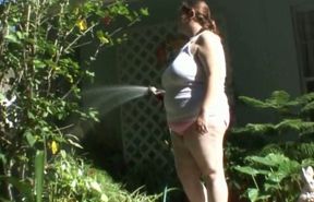 Horny BBW whore plays with a hose in the garden while stripping