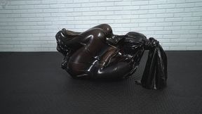 A black transparent latex cocoon inside which a woman tries to escape but cannot