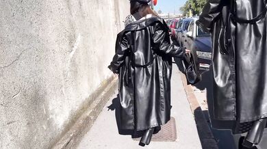 Leather clad dominatrix smokes while strutting in her boots