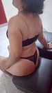 Sentada en un banquito en motel