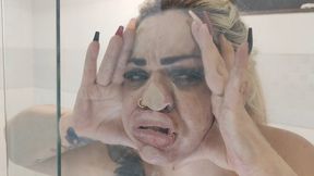 The blonde's big face squeezed into the glass.