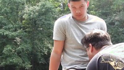 Twink and muscled guy are blowing one another in the yard