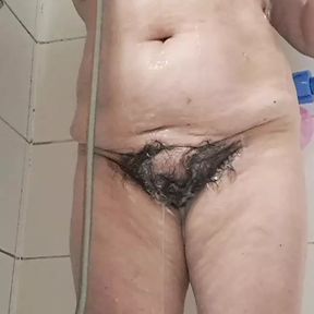 Mature milf bathing her tits and hairy pussy gets excited by the water