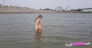 Naked girl masturbates on the river shore