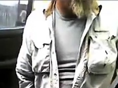 Bearded daddy strokes his cock by his truck outdoors.