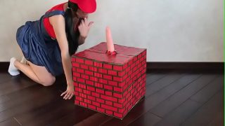 Nerdige weibliche Mario-Cosplayerin reitet großen Dildo