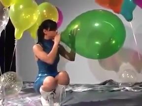 Sexy Girl In Latex Dress Blows to Pop Some Big Balloons
