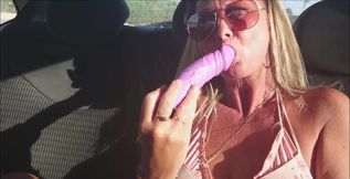 Fucking a dildo in the backseat of a car parked on a busy road. Giving a little masturbation encouragement.