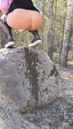 A Baltic girl urinates juicyly with a large stream while stepping on a stone.